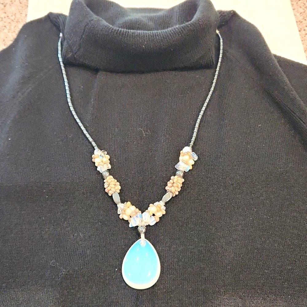 Beautiful artisan Shell and beaded necklace.  The large stone medallion glows.